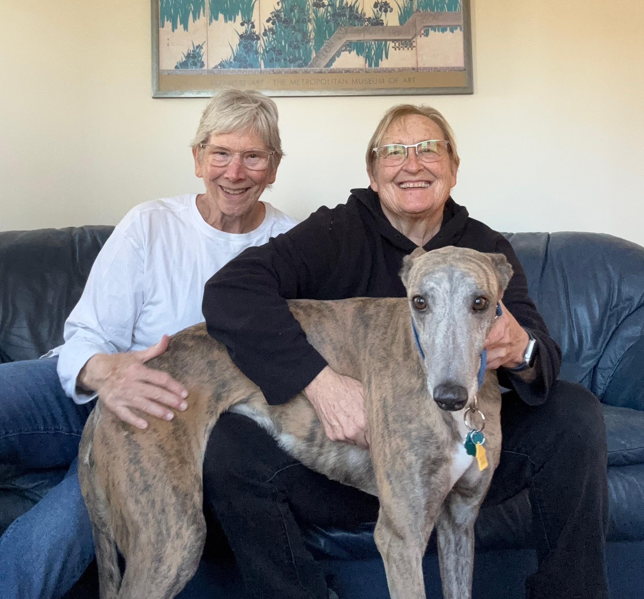Two adopters with their newly adopted greyhound.